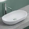 A white oval-shaped sink with a chrome faucet is placed on a gray countertop against a green wall. Produktbild-Vorschau