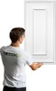 A man in a white t-shirt with the Verdico logo is holding a white 3D wall panel. Podgląd zdjęcia produktu