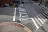 A person is running across a crosswalk in a city street. Náhľad obrázku produktu