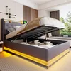 A modern bedroom with a bed that has its storage compartment open, revealing folded bedding and pillows. The bed has LED lighting around its base and headboard. Náhľad obrázku produktu