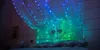 A bedroom scene with string lights draped over a bed canopy. Produktbild-Vorschau