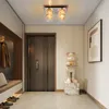 A modern hallway with a ceiling light, a door, a bench with coats, shoes, and a decorative bear statue. Podgląd zdjęcia produktu