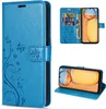 A collage of images showing a blue flip phone case with a floral and butterfly design, including a view of the case open with a phone and cards inside, and a view of the case standing up as a phone stand. Produktbild-Vorschau
