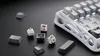 A disassembled mechanical keyboard with its components laid out on a black textured surface. Produktbild-Vorschau