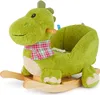 A green plush dinosaur rocking toy with a plaid scarf and wooden rockers, shown against a white background. Produktbild-Vorschau
