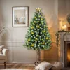 A decorated Christmas tree in a cozy living room setting, with a fireplace and candles in the background. Podgląd zdjęcia produktu
