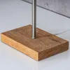 Close-up of the base of a lamp or decorative item, showing a wooden block and a metal pole. Produktbild-Vorschau