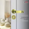 A close-up of a door handle and lock mechanism on a white door, with a blurred background of a room interior. Produktbild-Vorschau