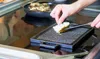 A person is using a grill pan on a stovetop. Anteprima dell’immagine prodotto
