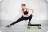 A woman is performing a lunge stretch on a step platform. Voir les images du produit
