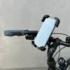 A close-up view of a bicycle handlebar with a smartphone mounted on it. Produktbild-Vorschau