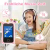 A young girl wearing headphones is happily singing while holding a pink MP3 player. Produktbild-Vorschau