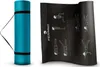 A teal yoga mat rolled up and secured with black straps and a carrying strap, next to an unrolled black yoga mat with instructional diagrams and the brand logo. Produktbild-Vorschau