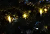 Close-up of Christmas tree lights shaped like candles, with tinsel. Produktbild-Vorschau