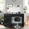 A modern vanity set with a black high-gloss finish, featuring a large mirror with integrated lighting, drawers, and a matching stool, set in a well-lit room with plants and decorative items. Produktbild-Vorschau
