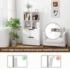 A white bookshelf with two drawers is shown in a room with a chair and a plant. There are also diagrams illustrating anti-tip safety features. Podgląd zdjęcia produktu