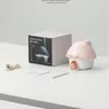 A mushroom-shaped humidifier and its packaging are displayed on a white surface. Produktbild-Vorschau