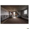 A modern living room with a large sectional sofa, a rug, and a view through the windows. Produktbild-Vorschau