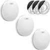 Three white smoke detectors and three rolls of adhesive tape on a white background. Produktbild-Vorschau