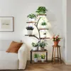 A multi-tiered plant stand with integrated grow lights is placed next to a sofa in a living room. Produktbild-Vorschau