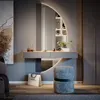 A modern vanity table with a large circular mirror and integrated shelving, set in a stylish room with a stool and artwork. Produktbild-Vorschau