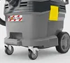 A close-up view of the lower section of a Kärcher professional wet/dry vacuum cleaner, focusing on its wheels and a warning sticker. Voir les images du produit