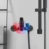 A close-up shot of a black shower faucet with red and blue indicators for hot and cold water. Náhled obrázku produktu