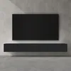 A modern, minimalist living room setup featuring a wall-mounted television above a floating media console against a concrete wall. Produktbild-Vorschau