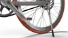 A close-up view of a bicycle's rear wheel, crankset, and kickstand. Anteprima dell’immagine prodotto