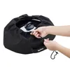 Hands are shown adjusting a drawstring on a black fabric cover for a cooking pot. Produktbild-Vorschau