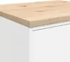 A close-up view of the top corner of a white cabinet with a wooden top. Produktbild-Vorschau