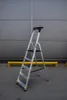 A step ladder is shown in front of a gray building. Produktbild-Vorschau
