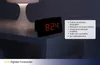 A digital alarm clock is shown on a nightstand next to a lamp in a dark room. A text box with product features is overlaid on the right side of the image. Anteprima dell’immagine prodotto