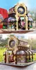 A person is holding a Lego-like botanical garden model in the top image, and the model is displayed outdoors in the bottom image. Anteprima dell’immagine prodotto
