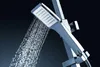 A close-up shot of a modern chrome shower head with water spraying from it against a dark background. Náhľad obrázku produktu
