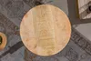 A top-down view of a round wooden table on a patterned rug. Produktbild-Vorschau