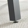 A close-up view of a black metal table leg with an adjustable foot resting on a textured white carpet. Podgląd zdjęcia produktu