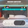 A close-up view of a modern upholstered bed with integrated LED lighting and storage features. Produktbild-Vorschau