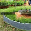 Graue Gartenumrandung mit Steinoptik, installiert in einer gebogenen Form um eine Grasfläche neben einer Holzterrasse Anteprima dell’immagine prodotto