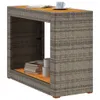 A vidaXL garden side table with a wooden top and gray poly rattan weave is shown against a white background. Books and cylindrical containers are on the lower shelf. Náhled obrázku produktu