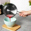A hand is pouring red liquid from a stainless steel pot into a light blue bowl. Produktbild-Vorschau