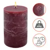 A large, rustic burgundy pillar candle with a lit wick, shown on a white background with informational icons on the right. Anteprima dell’immagine prodotto