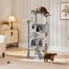 A multi-level cat tree with two cats interacting with it, placed in a living room setting. Produktbild-Vorschau