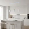 A modern kitchen island with bar stools and a pendant light fixture hanging above. Náhľad obrázku produktu