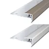 Two identical stair nosing profiles, one in a silver finish and the other in a bronze/brown finish, are shown against a white background. Produktbild-Vorschau
