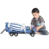 A young boy is playing with a toy cement mixer truck. Podgląd zdjęcia produktu