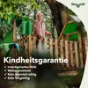 A young girl is playing on a wooden playground structure in a forest setting. Podgląd zdjęcia produktu