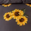 A close-up view of a dark gray fabric with a pattern of yellow sunflowers and green leaves. Anteprima dell’immagine prodotto