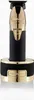 A close-up studio shot of a gold and black hair trimmer on its charging stand. Voir les images du produit