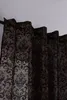A close-up view of brown damask patterned curtains hanging from a curtain rod against a white ceiling. Produktbild-Vorschau